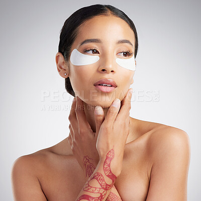 Buy stock photo A beautiful mixed race woman wearing under eye patches. Hispanic model with glowing skin using hydrating treatment against a grey copyspace background