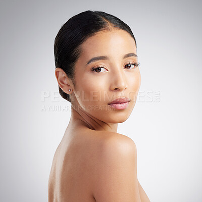 Buy stock photo Portrait of a confident young beautiful mixed race woman grooming and looking confident. A hispanic woman's selfcare routine for natural glowing skin against a grey studio copyspace background