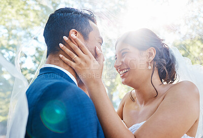 Buy stock photo Joyful bride and groom enjoying romantic moments on their wedding day. Newlywed couple standing face to face while wife touches husbands face