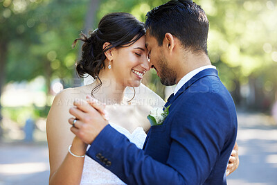 Buy stock photo Bride and groom dancing outside. Mixed race newlyweds enjoying romantic moments on their wedding day. Happy young romantic couple sharing a dance in nature