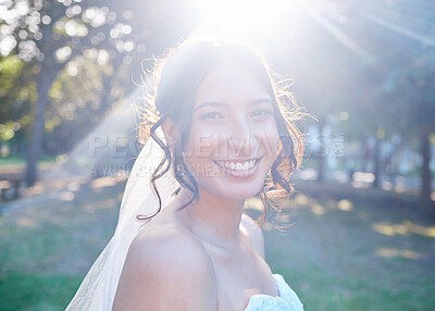 Buy stock photo Stunning mixed race bride smiling while posing against greenery on a sunny day. A happy bride wearing a veil with beautiful brown locks in a up-style and natural make-up