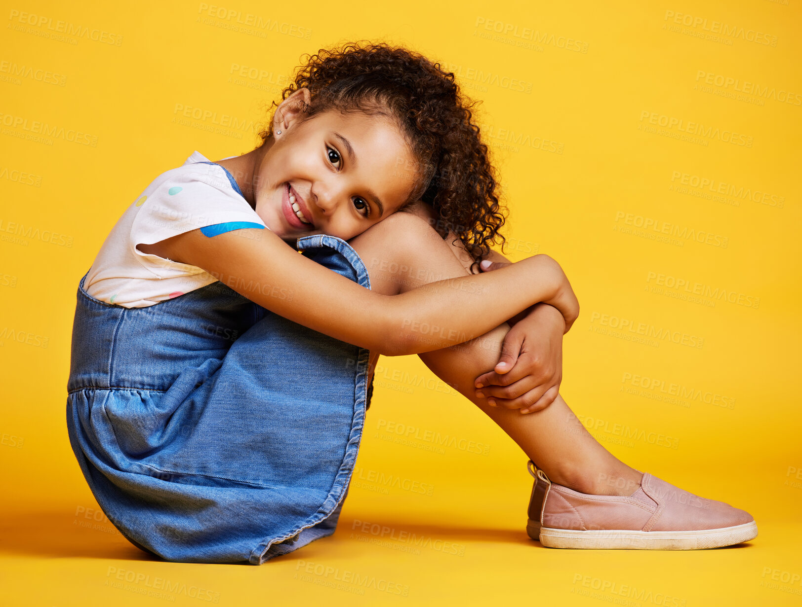 Buy stock photo Portrait, happy and girl child on studio floor for children fashion, playful and sweet against yellow background. Face, little and smile by kid with self love, pose and relax while sitting isolated