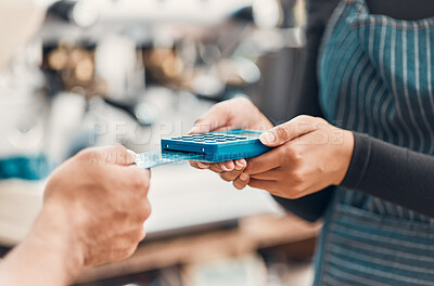Closeup of a clerk accepting a credit card payment from a customer in a cafe or store. Hands of woman using card machine reader to process cashless transaction for a purchase from a man in a shop