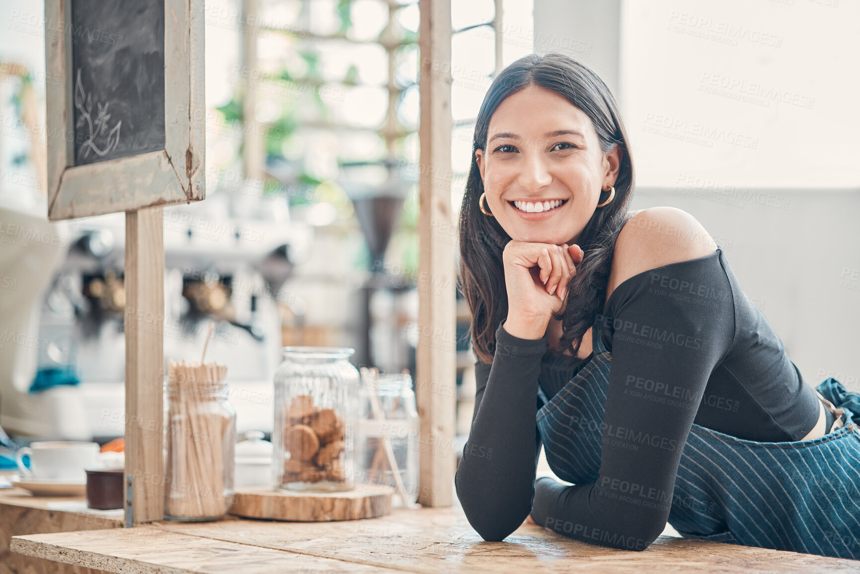 Buy stock photo Portrait of one happy young hispanic waitress working in a store or cafe. Friendly woman and coffeeshop owner managing a successful restaurant startup