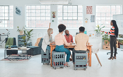 Group of diverse businesspeople having a meeting in a modern office at work. Young african american businesswoman doing a presentation of an idea on a whiteboard in a boardroom with colleagues. Businesspeople planning together