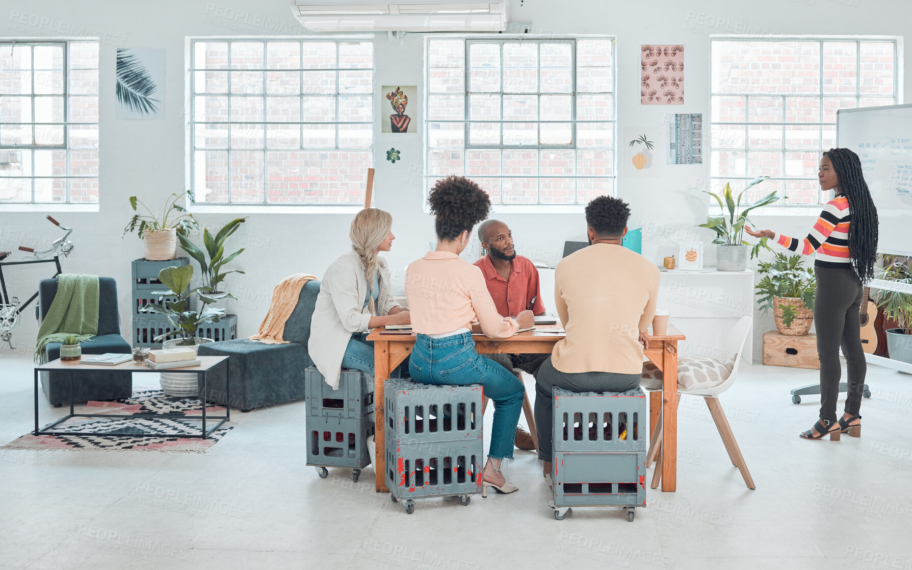 Buy stock photo Group of diverse businesspeople having a meeting in a modern office at work. Young african american businesswoman doing a presentation of an idea on a whiteboard in a boardroom with colleagues. Businesspeople planning together