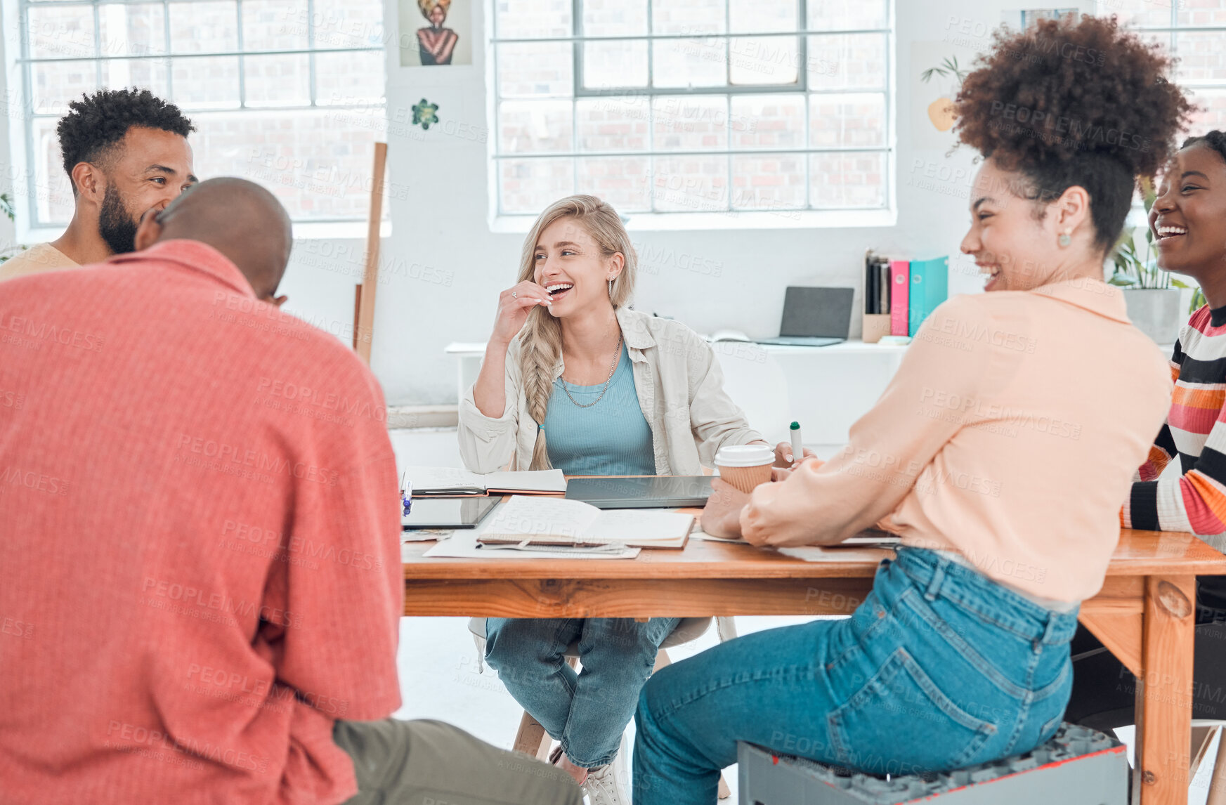 Buy stock photo Group of happy diverse businesspeople having a meeting in a modern office at work. Joyful colleagues laughing and talking while sitting at a table. Creative businesspeople planning together