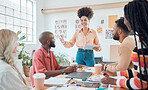 Group of diverse businesspeople having a meeting in a modern office at work. Young happy hispanic businesswoman with a curly afro doing a presentation of an idea using a digital tablet in a boardroom with colleagues. Businesspeople planning together