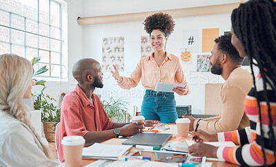 Buy stock photo Group of diverse businesspeople having a meeting in a modern office at work. Young happy hispanic businesswoman with a curly afro doing a presentation of an idea using a digital tablet in a boardroom with colleagues. Businesspeople planning together