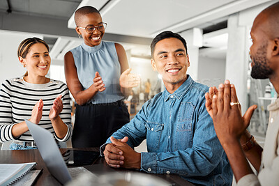 Group of diverse businesspeople having a meeting in an office at work. Happy business professionals clapping for their colleagues achievement together. Happy businessman being applauded by his coworkers