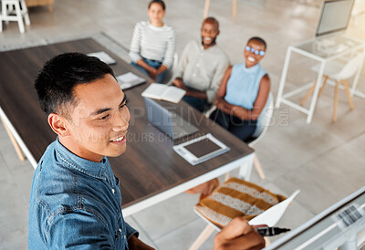 Buy stock photo Group of diverse businesspeople having a meeting in an office at work. Young happy mixed race businessman smiling while writing an idea on a whiteboard in a boardroom with colleagues. Businesspeople planning together