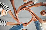 Group of businesspeople forming a circle with their hands in an office at work. Colleagues having fun and making a shape with their hands together. Coworkers showing support and motivation for each other