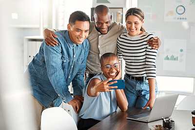 Buy stock photo Group of young cheerful businesspeople taking a selfie together at work. Happy african american businesswoman taking a photo with her colleagues on her phone in an office