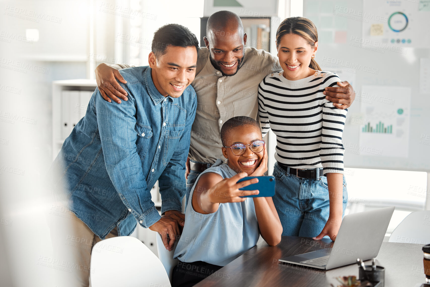 Buy stock photo Group of young cheerful businesspeople taking a selfie together at work. Happy african american businesswoman taking a photo with her colleagues on her phone in an office
