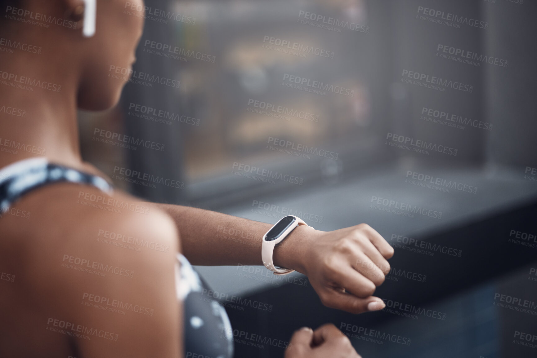 Buy stock photo Closeup of one mixed race woman checking time on digital wristwatch with blank display screen while running outdoors. Female athlete wearing fitness tracker on arm to monitor progress, heart rate and calories burned during training exercise in the city