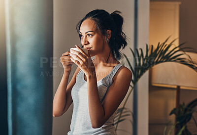 Buy stock photo A beautiful young Hispanic woman enjoying a warm cup of coffee for breakfast. One mixed race female drinking tea while looking at the view from a window in her apartment