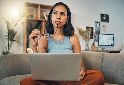 Buy stock photo Thinking, laptop and woman Editor doing remote work in her home, apartment or house with an idea working from a sofa. Confused, decision and female person contemplating and planning in a living room