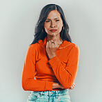One mixed race woman isolated against grey studio background with copyspace. Young hispanic standing alone and thinking. Contemplative model with finger on chin planning and coming up with an idea