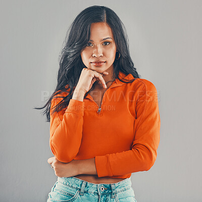 Portrait of mixed race woman isolated against grey studio background with copyspace and feeling flirty. Young, sultry, seductive hispanic standing alone. One model posing with confidence and attitude