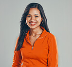Portrait of smiling mixed race woman isolated against grey studio background with copyspace. Beautiful young hispanic standing alone and feeling happy. One brunette model feeling confident and posing