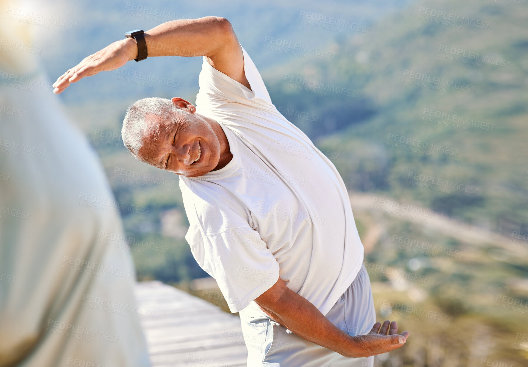 Buy stock photo Senior man laughing while stretching his hand over his head while exercising outdoors. Mixed race man staying fit with yoga classes. Finding inner peace, balance and living healthy