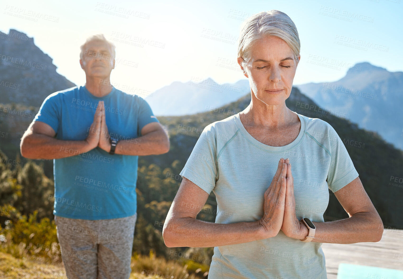 Buy stock photo Senior couple meditating with joined hands and closed eyes breathing deeply. Mature couple doing yoga in nature living a healthy and active lifestyle in retirement