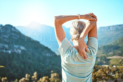 Buy stock photo Rear view of a senior woman with grey hair stretching with her hands behind her head while standing outdoors and overlooking a scenic mountain view. Living healthy active lifestyle