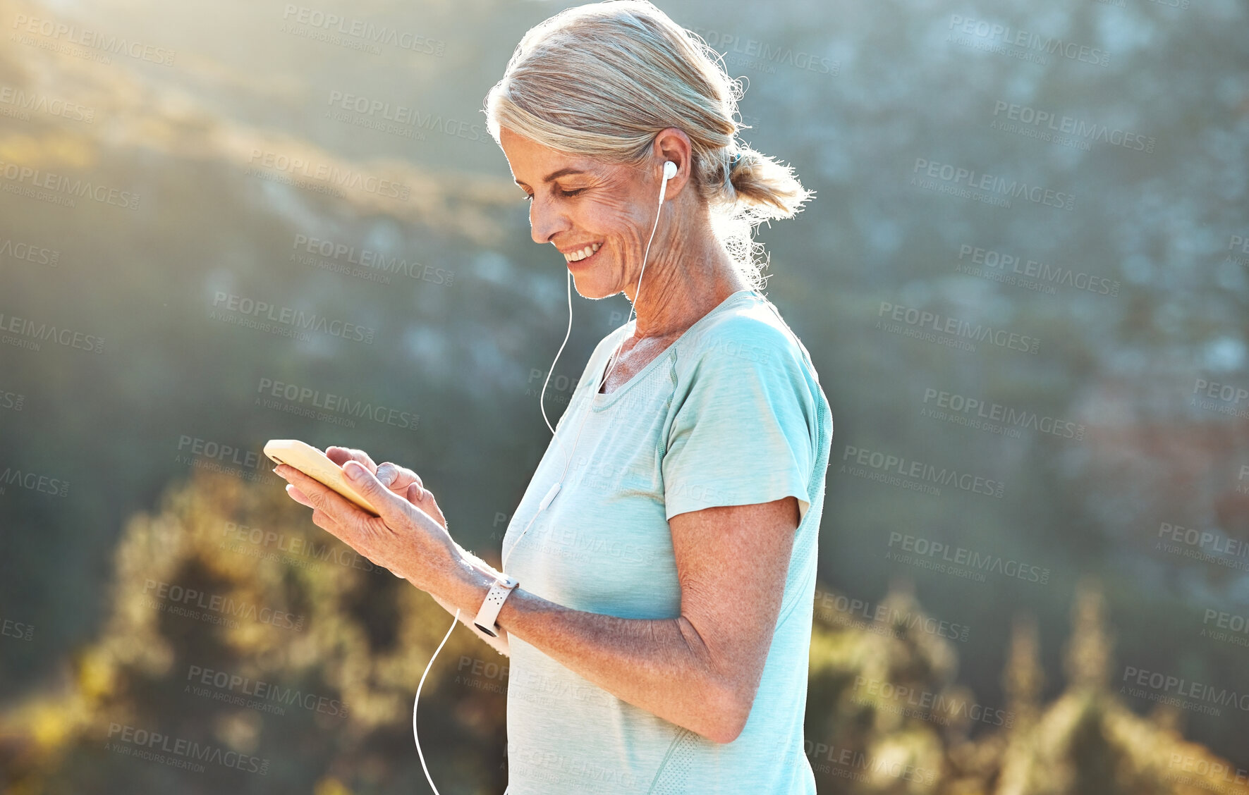 Buy stock photo Senior, happy woman and listening with earphones on mountain for music or audio streaming in nature. Mature, female person or yogi with smile or headphones on mobile smartphone for audio podcast