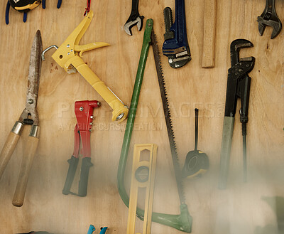 Buy stock photo An arrangement of tools on a wooden wall. Closeup of a collection of tools hanging. Neat, tidy mechanics tools and equipment on a wall. Still life of tools in storage. Various tools in a workshop