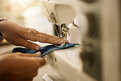 Buy stock photo Zoom into hands of a seamstress sewing a piece of fabric. Fashion designer stitching a piece of fabric.Closeup of designer tailoring denim textile in a sewing machine.Tailor using a sewing machine