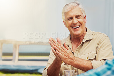 One smiling senior caucasian man clapping while enjoying wine tasting day on a farm with copyspace. Happy man sitting alone outside during summer on a vineyard during the weekend. Old man on wine farm