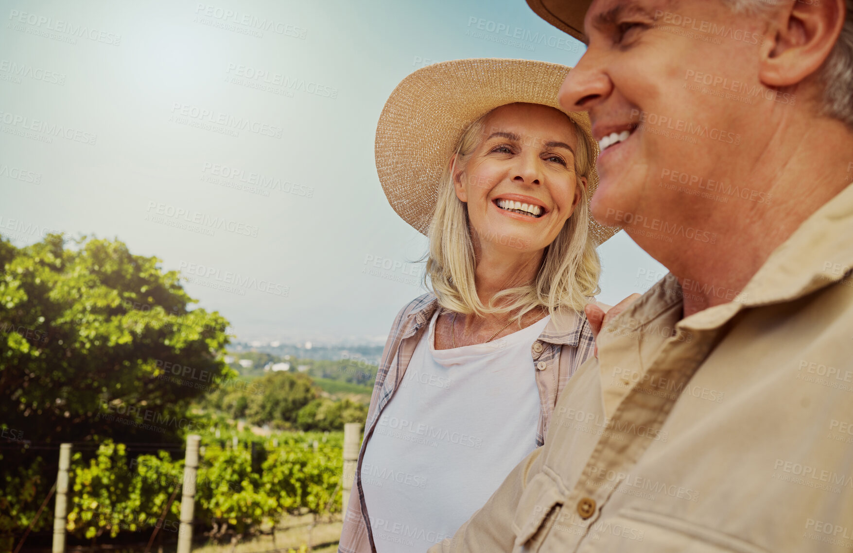 Buy stock photo Smiling senior couple bonding during day on a farm with copyspace. Happy caucasian husband and wife standing close together on vineyard in summer. Elderly husband and wife feeling in love on wine farm