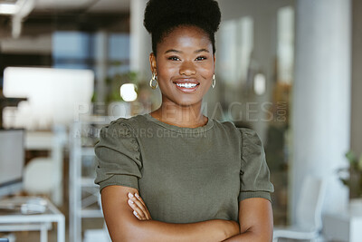 Buy stock photo Young happy african american businesswoman standing with her arms crossed alone at work. One cheerful black woman with an afro smiling while standing in an office