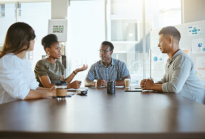 Buy stock photo Group of diverse businesspeople having a meeting in an office at work. Happy african american businesswoman talking during a workshop at a table with coworkers. Businesspeople planning together