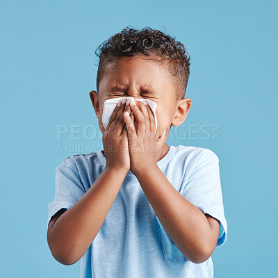Buy stock photo Sick, blowing nose and a boy with a tissue with covid isolated on a blue background in a studio. Health, young and a little boy with an allergy problem, virus and sneezing from a cold on a backdrop