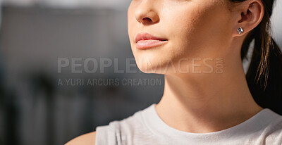 Closeup of one focused caucasian woman exercising in a gym with copyspace on the side. Face of a determined and motivated female athlete with healthy skin looking thoughtful in a fitness centre