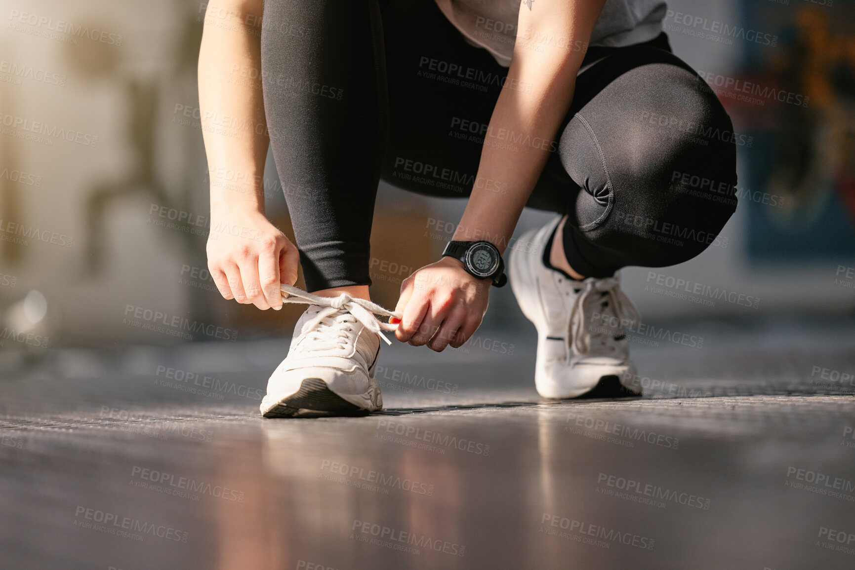 Buy stock photo Closeup of one active caucasian woman tying her shoelaces while exercising in a gym. Female athlete fastening sneaker footwear for a comfortable fit and to prevent tripping during a training workout in a fitness centre