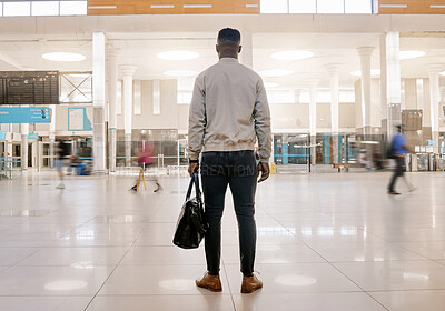 Buy stock photo Black Rear view of African american businessman travelling alone and walking in a train station while wearing a mask for protection against coronavirus travelling alone