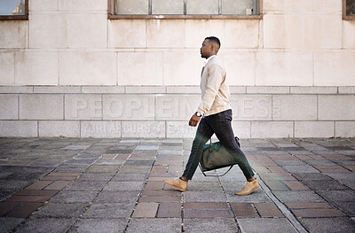 Black businessman travelling alone.A african american businessman walking around town with his luggage while looking stylish in the city