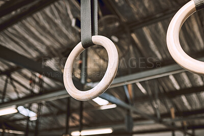 Hanging acrobat rings in emtpy gym. Gymnastic rings hanging in a gym. Gym equipment hanging in an empty gym. Exercise object hanging in the gym. Rings hanging in a neat gym