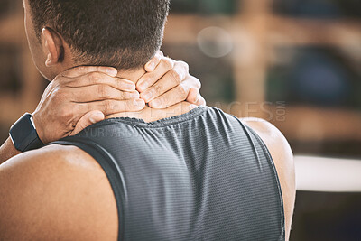 Buy stock photo Back of a fit man experiencing pain. Athlete experiencing neck pain in the gym. Muscular trainer with back pain in the gym. Bodybuilder athlete discomfort in his neck during a workout