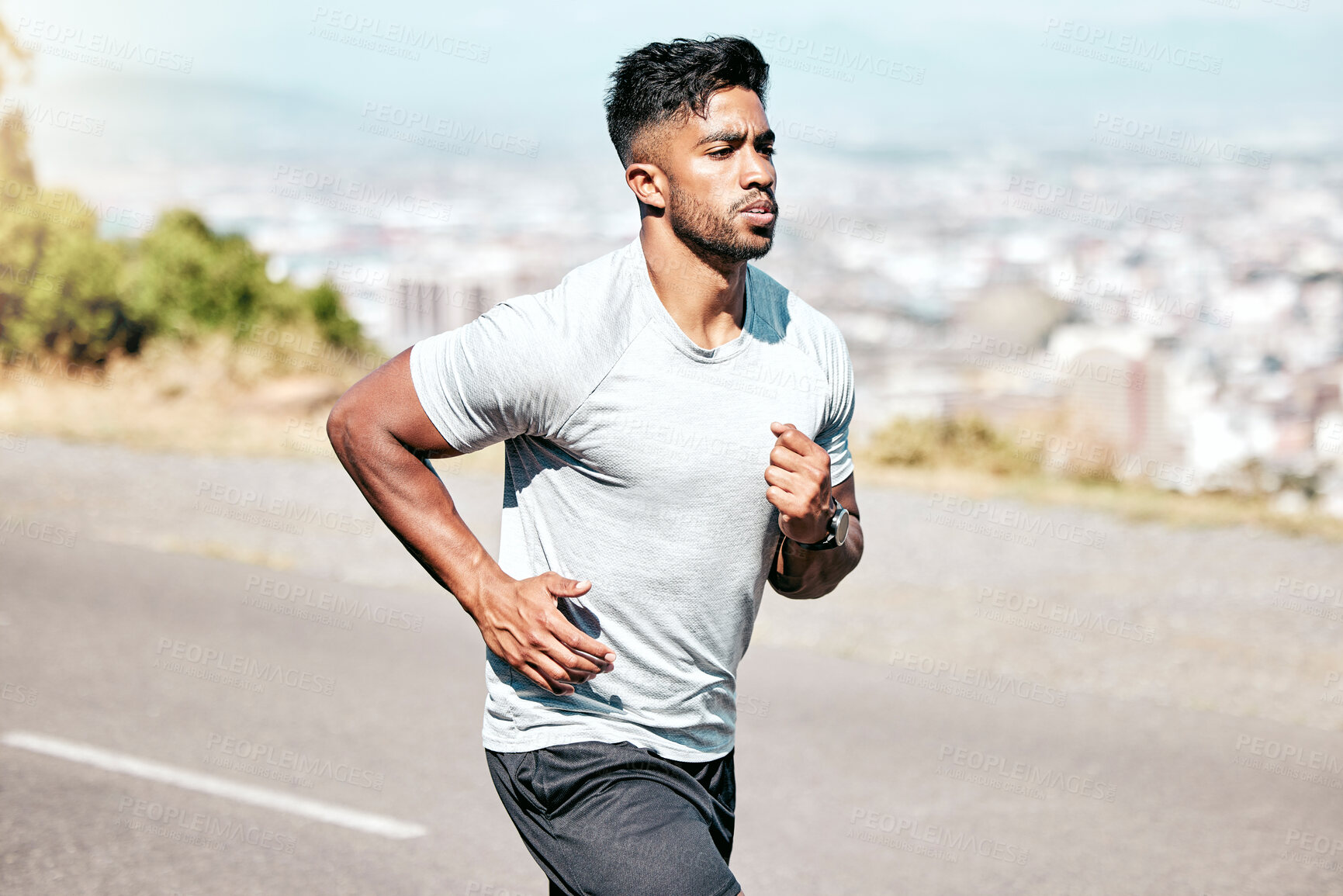 Buy stock photo Athletic young mixed race man sprinting outdoors in nature. Fit handsome hispanic male athlete man out for a run. Fitness cardio and endurance training for a sprint or long distance marathon