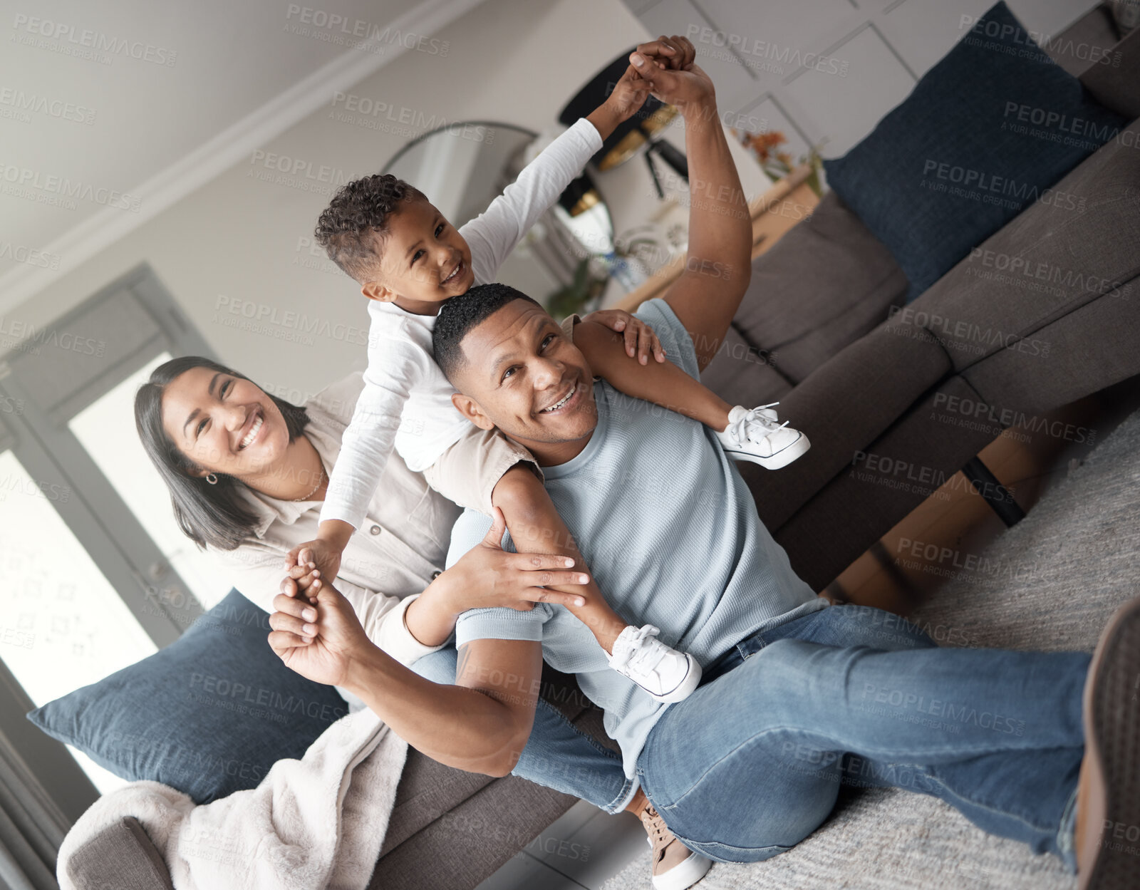 Buy stock photo Happy kid, home and parents play piggyback games on living room floor for fun, quality time and relax. Mom, dad and boy child flying on shoulders for love, happiness and support of family in lounge