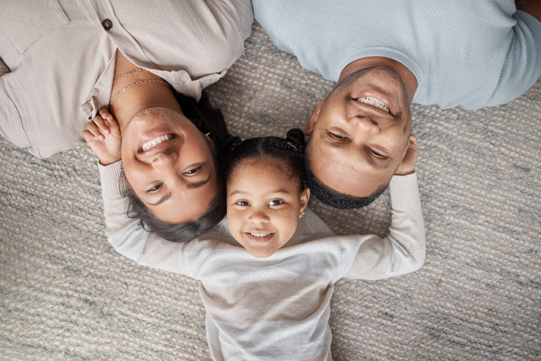 Buy stock photo Top view, parents and happy portrait of kid for love, care and bonding for quality time together at home. Face of mom, dad and happiness of girl child, family and relax in house for fun, joy and play