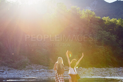 Women taking a break during a hiking trip and celebrating. Carefree women celebrating during a hiking trip to the mountains together. Carefree friends taking a break during a hike to celebrate