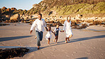 Full length of a carefree young african american family with two children holding hands and having fun while running on the beach. Loving parents enjoying vacation with cheerful little daughter and son