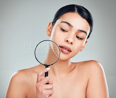 Buy stock photo A beautiful mixed race woman posing with a magnifying glass. Young hispanic obsessed with targeting acne and wrinkles against a grey copyspace background