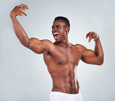 Buy stock photo One excited African American fitness model posing topless in a underwear and looking muscular. Happy black male athlete isolated on grey copyspace in a studio wearing boxers