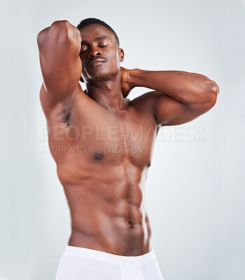 Buy stock photo One African American fitness model posing topless in underwear and looking muscular. Confident black male athlete isolated on grey copyspace in a studio wearing boxers