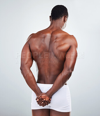 Buy stock photo Rear view of one African American fitness model posing topless in a underwear and looking muscular. Black male athlete wearing boxers isolated on grey copyspace in a studio